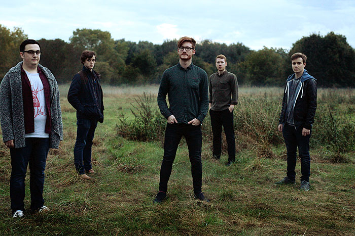 Alex Esp in The Yacht Club Fall band shot in a field